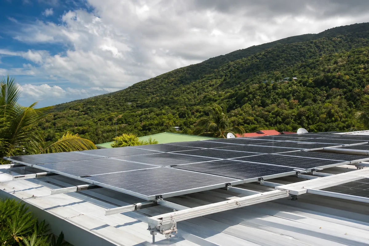 Panneaux photovoltaïques installés sur le toit d’une maison créole en Guadeloupe sous ciel dégagé